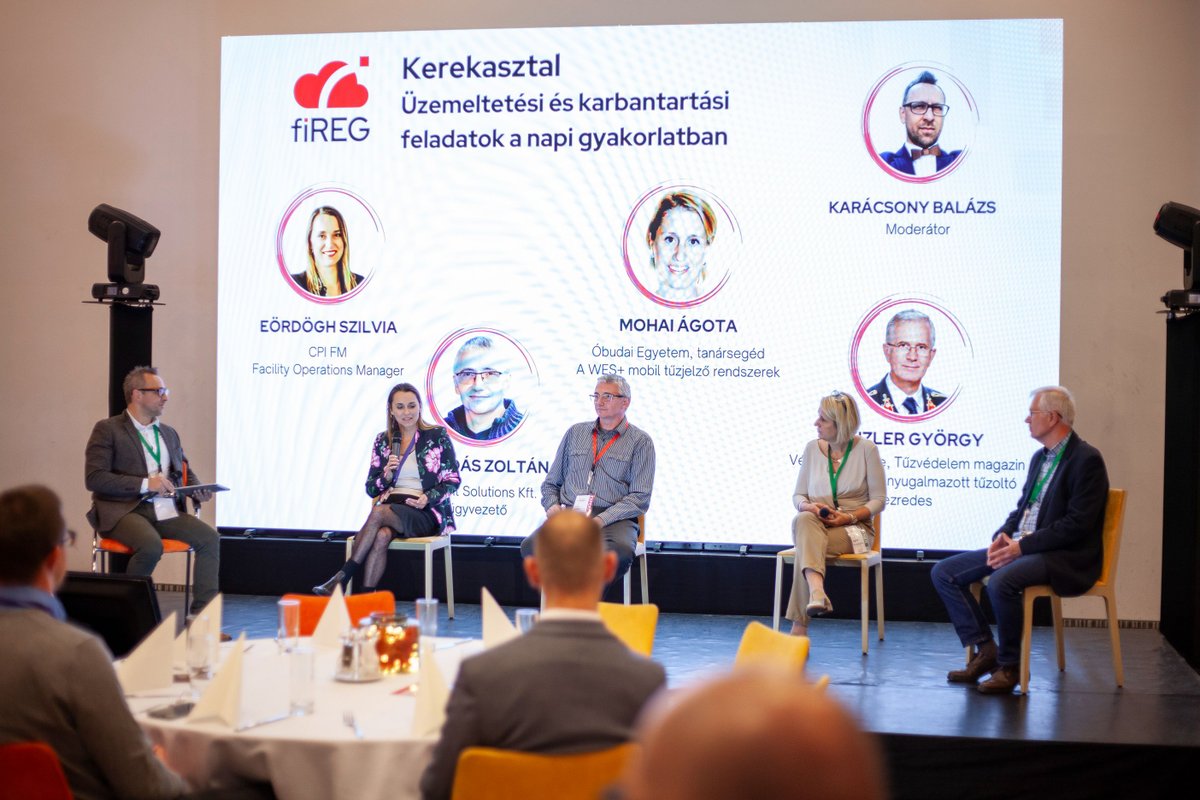 Kerekasztal-beszélgetés a színpadon, a kivetítőn: Üzemeltetési és karbantartási feladatok a napi gyakorlatban